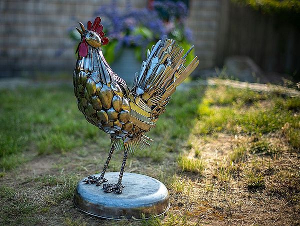 Photo of a rooster made up of silver utensils